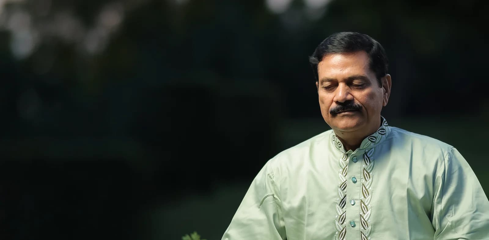Anando seated in meditation in a garden